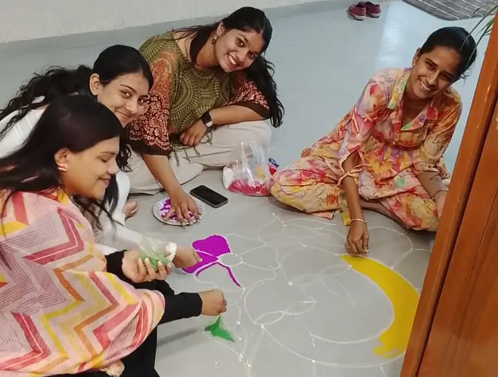 Warm, smiling photo of three GIAS employees in brightly colored ethnic wear.