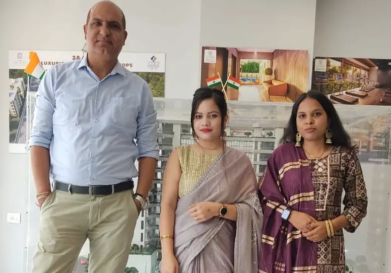 Three GIAS staff members smiling, dressed in bright traditional Indian clothing.