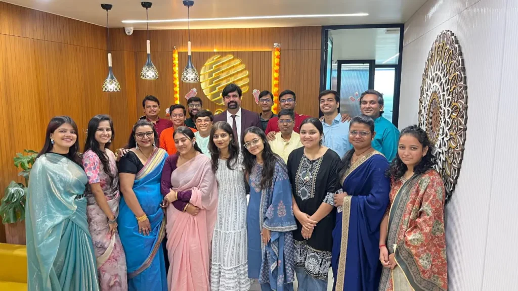 Large group of GIAS employees smiling in the office during a celebration.